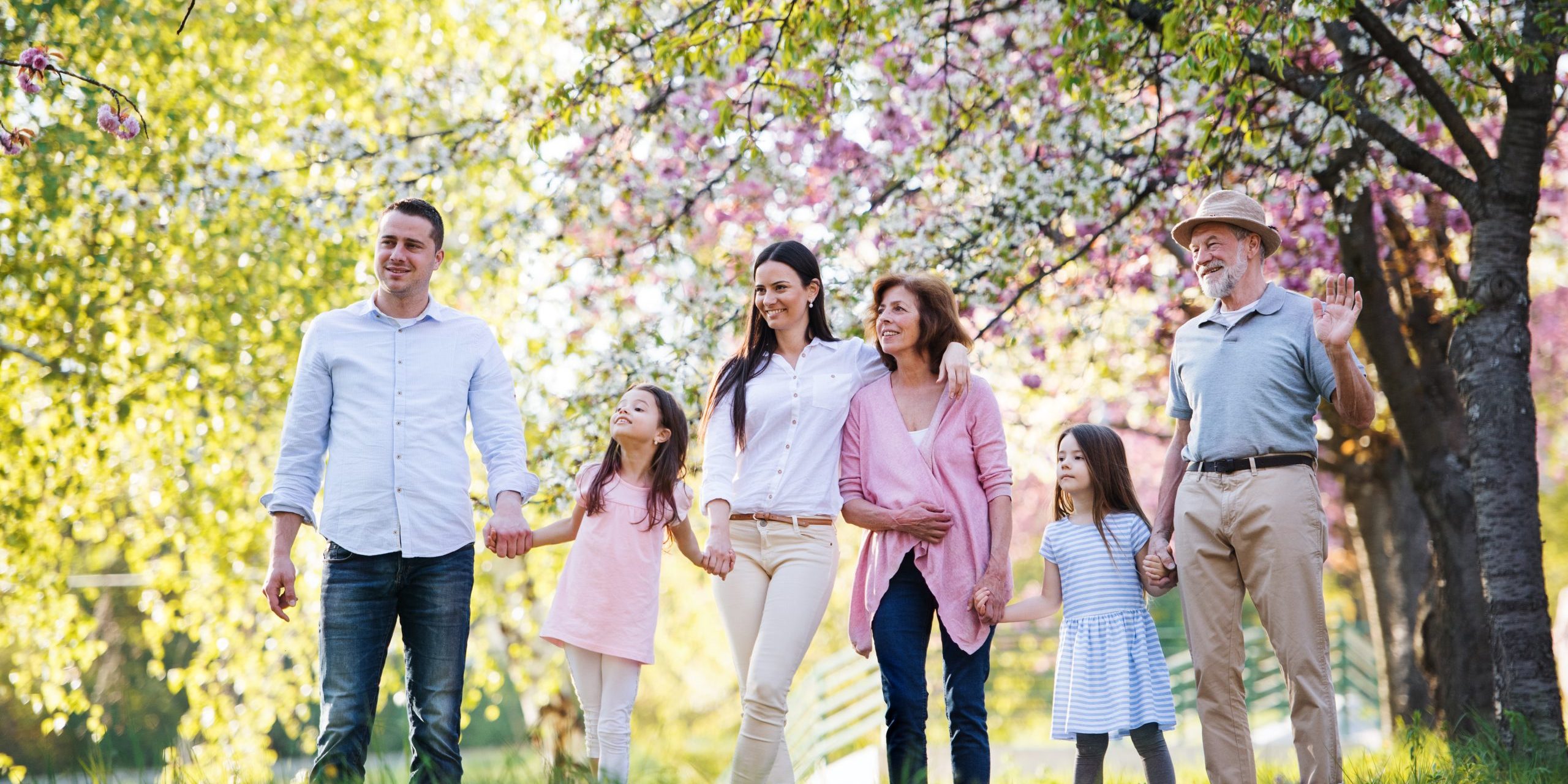Three generation family walking outside in spring nature.