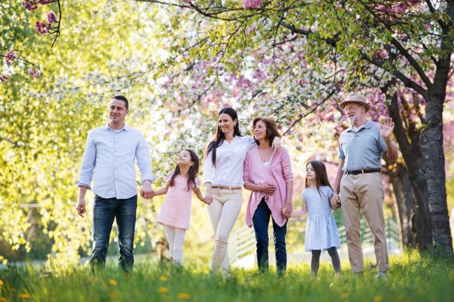 Three generation family walking outside in spring nature.