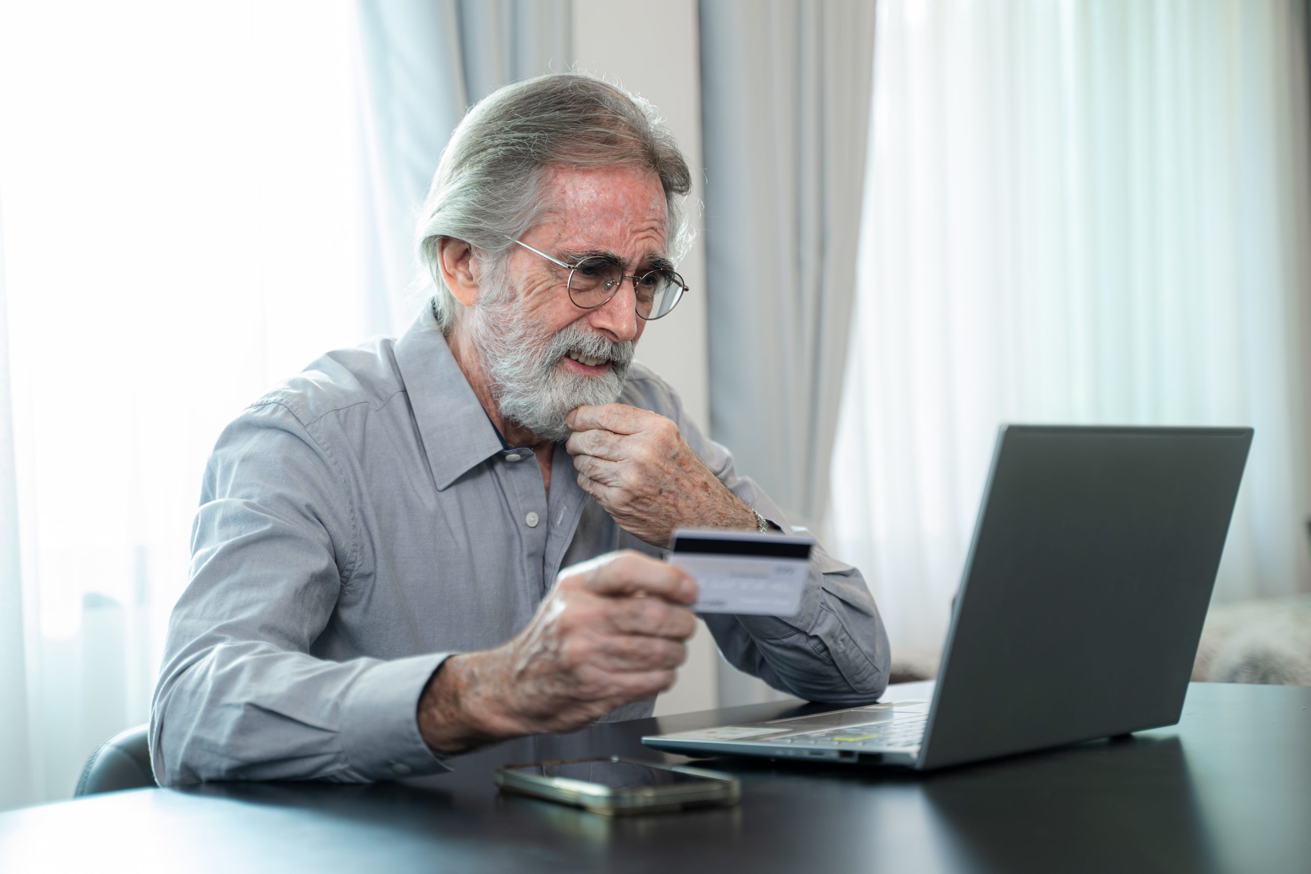 RetireHow Do I Protect Myself From Financial Scams When I Get Older?ment and Credit Cards,Smart senior male pay bills or shop